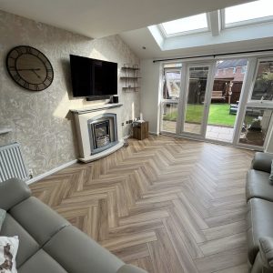 Natural oak SPC herringbone flooring installed in a living room